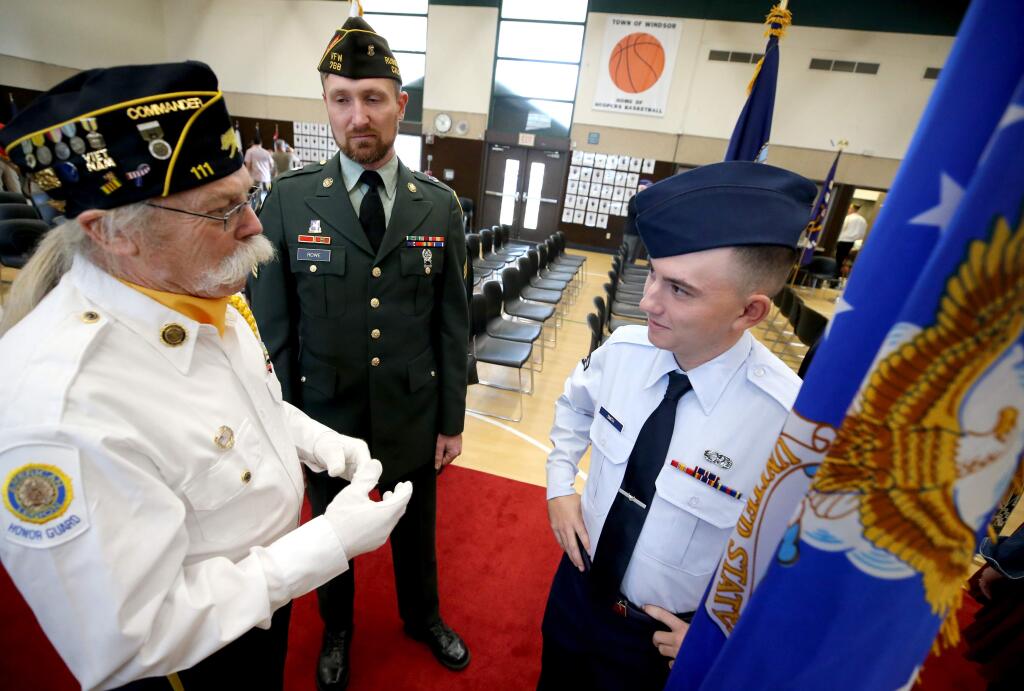 Air Force service member Evan Smith, right, talks with Army veteran Jude Rowe, center, and Air Force Veteran Tim Madura, left, following the Hometown Heros Military Banner Ceremony at the Huerta Gymnasium in Windsor on Sunday, January 27, 2019. (BETH SCHLANKER/ The Press Democrat)
