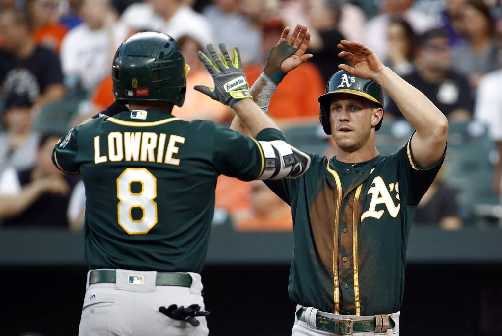 Oakland Athletics' Boog Powell, right, greets teammate Jed Lowrie at home plate after scoring on Lowrie's two-run home run in the first inning of a baseball game against the Baltimore Orioles in Baltimore, Tuesday, Aug. 22, 2017. (AP Photo/Patrick Semansky)