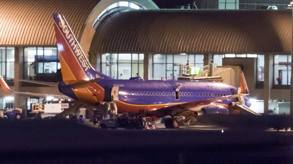 In this Monday, Feb. 12, 2018 photo, a Southwest Airlines plane sits it a gate after passengers had to evacuate before takeoff because of a fire at John Wayne Airport in Santa Ana, Calif. Federal Aviation Administration spokesman Allen Kenitzer says the blaze was in the airliner's auxiliary power unit and was extinguished with the plane's fire suppression system (Leonard Ortiz/The Orange County Register via AP)