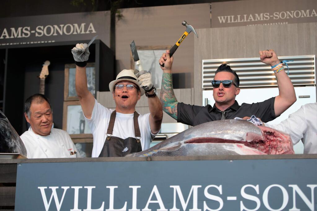 Chef Morimoto (L), breaks a knife while trying to filet a 162 pound tuna with Tre' Cool from Green Day at the 2016 BottleRock event. (Photo: Will Bucquoy)