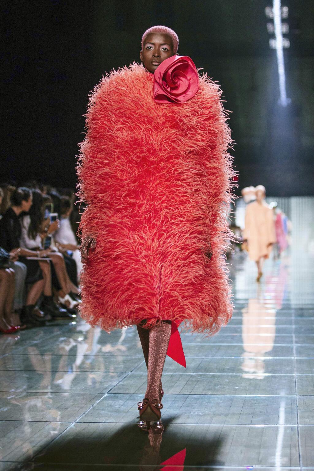 FILE - This Sept. 12, 2018 file photo shows a model wearing a coral outfit from the Marc Jacobs spring 2019 collection during Fashion Week in New York. Pantone Color Institute has chosen the color Living Coral as its 2019 color of the year. (AP Photo/Kevin Hagen)
