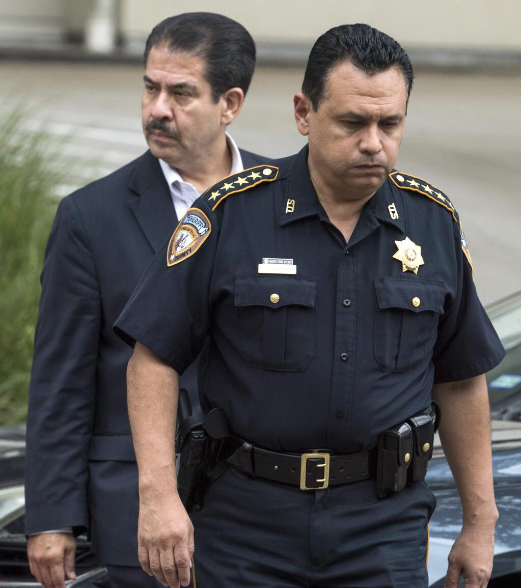 Harris County Sheriff Ed Gonzalez and Adrian Garcia walk outside Memorial Hermann Hospital after Deputy Sandeep Dhaliwal was transported there after he was shot and killed on Friday, Sept. 27, 2019, in Houston. Deputy Dhaliwal was shot and killed after a traffic stop in Cypress. (Brett Coomer/Houston Chronicle via AP)
