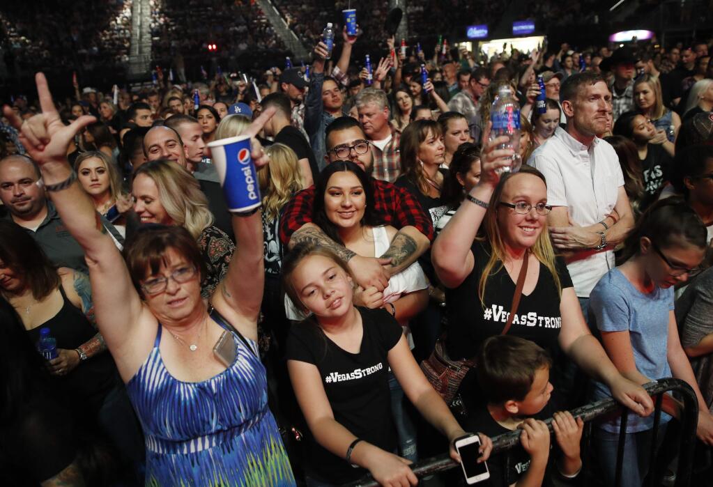 People listen to Big & Rich perform during a benefit concert honoring first responders and those affected by the recent Las Vegas mass shooting, Thursday, Oct. 19, 2017, in Las Vegas. Some survivors of the mass shooting said they were ready for closure, though they confessed feeling engulfed by anxiety and security fears while gathering in a large group for the first time since the attack. (AP Photo/John Locher)