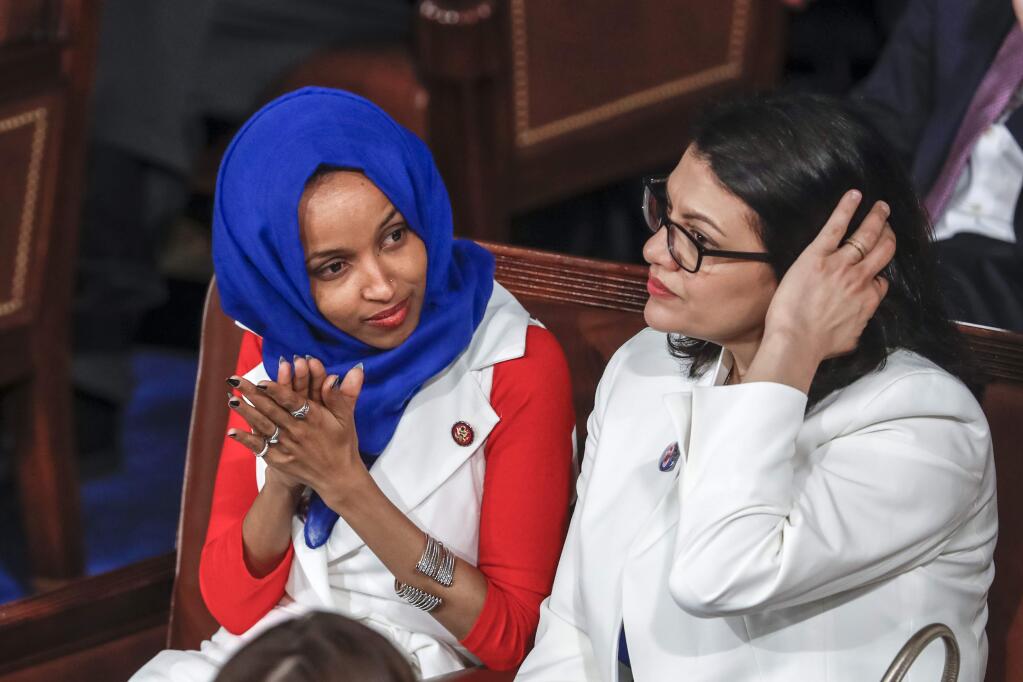 FILE - In this Feb. 5, 2019 file photo, Rep. Ilhan Omar, D-Minn., left, joined at right by Rep. Rashida Tlaib, D-Mich., listen to President Donald Trump's State of the Union speech, at the Capitol in Washington. Israel's prime minister is holding consultations with senior ministers and aides to reevaluate the decision to allow two Democratic Congresswomen to enter the country next week. A government official said Thursday, Aug. 15, 2019, that Benjamin Netanyahu was holding consultations about the upcoming visit of Omar and Tlaib, and that 'there is a possibility that Israel will not allow the visit in its current proposed format.' (AP Photo/J. Scott Applewhite, File)