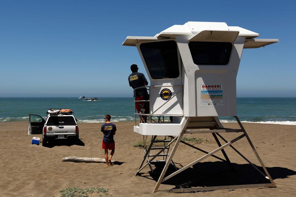 Lifeguards Blake Nogleberg, left, and Conor Bracken keep watch at Goat Rock State Beach near Jenner, California, on Friday, June 29, 2018. (Alvin Jornada / The Press Democrat)