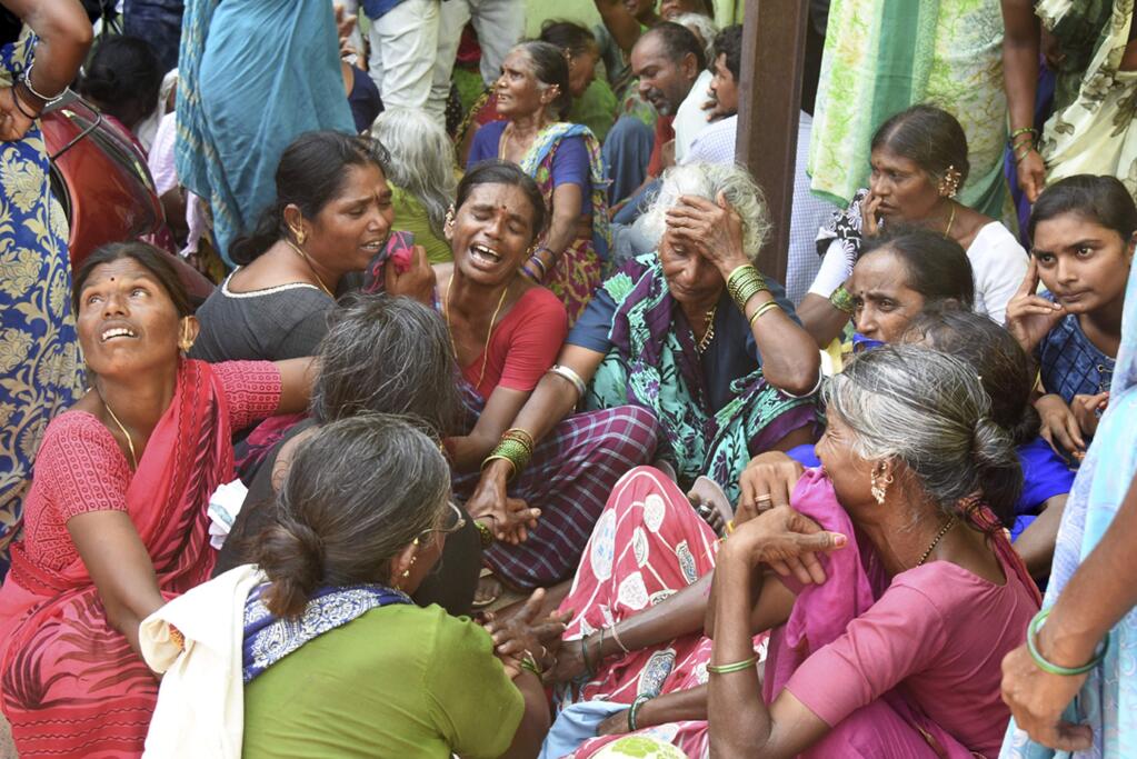 Relatives of victims of a bus accident wail near a hospital in Jagtiyal district of Telangana, India, Tuesday, Sept. 11, 2018. A bus carrying pilgrims from a Hindu temple in the hills of south India plunged off a road Tuesday, killing more than 50 people including four children, officials said. (AP Photo)