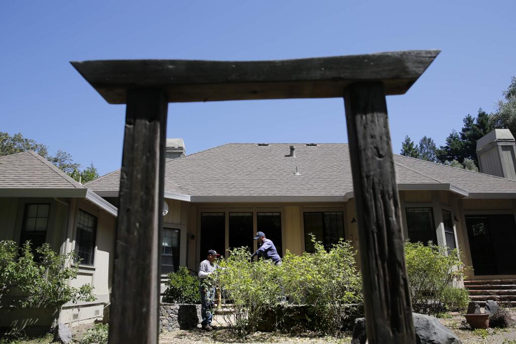 Alfredo Moreno, left, and Daniel Reyes from D R C Four Seasons Landscape Inc, prune the rose bushes at a home that was formerly rented and is now being sold in Santa Rosa on Thursday, June 14, 2018. (Beth Schlanker/ The Press Democrat)