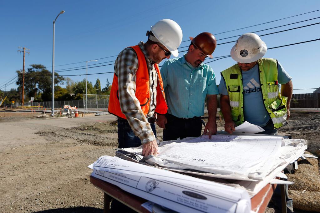 Sonoma County Regional Parks park planner Scott Wilkinson, left, Argonaut Constructors project manager Dan Giordani, and foreman Jim Payne discuss the blueprint layout of Andy's Unity Park in Santa Rosa, California on Thursday, September 28, 2017. The park recently received a boost in funding after the Board of Supervisors approved a $1 million grant from the Sonoma County Agriculture and Open Space District. (Alvin Jornada / The Press Democrat)