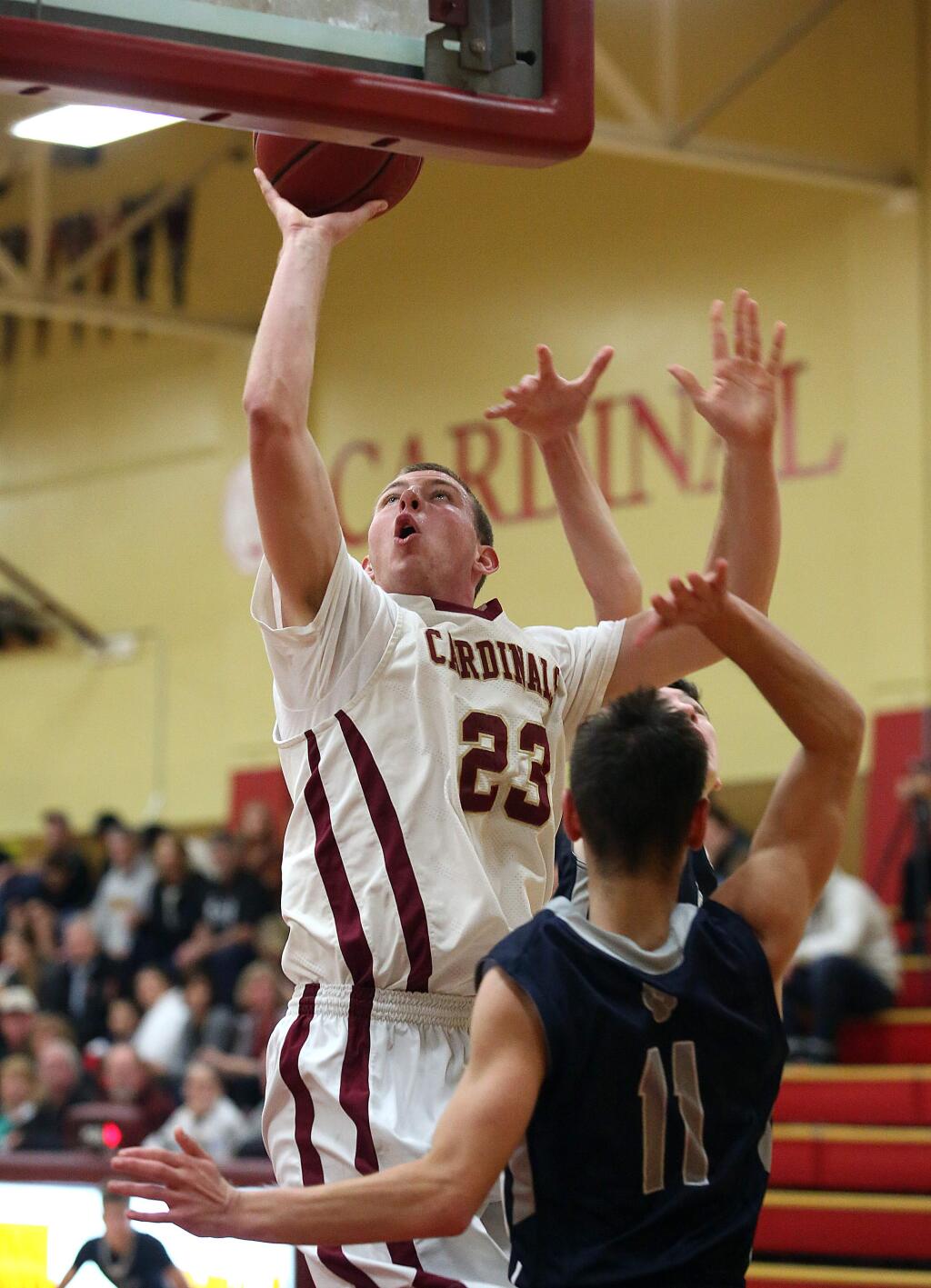 Cardinal Newman's James Ryan goes up to the basket as Marin Catholic's Sepehr Agnese defends during the game held at Cardinal Newman High School, Tuesday, December 2, 2014. (Crista Jeremiason / The Press Democrat)