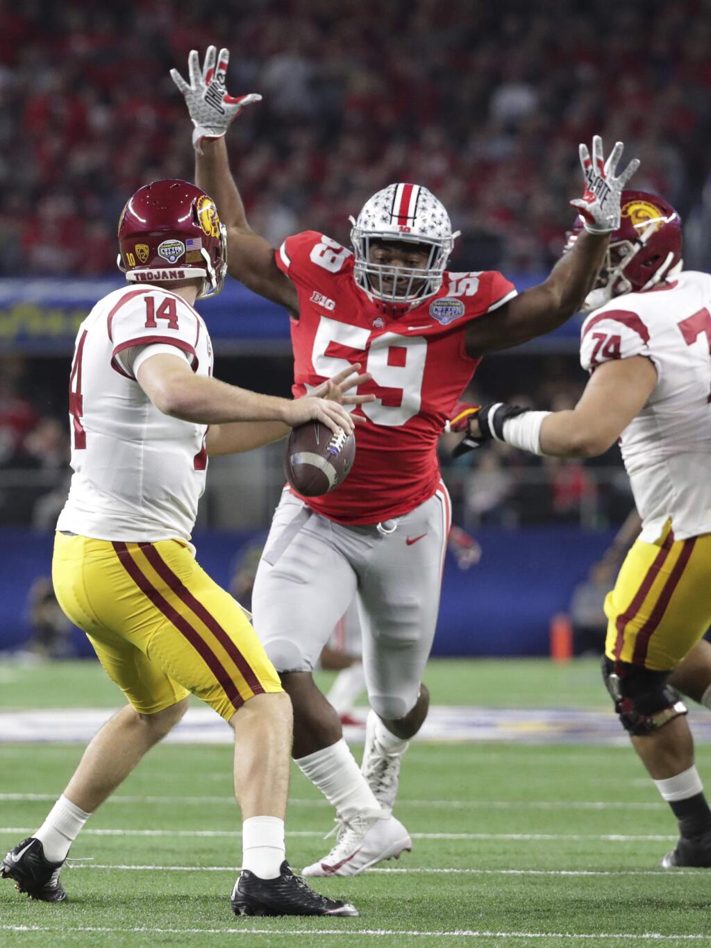 Ohio State defensive lineman Tyquan Lewis (59) closes in on Southern California quarterback Sam Darnold (14) during the first half of the Cotton Bowl NCAA college football game in Arlington, Texas, Friday, Dec. 29, 2017. (AP Photo/LM Otero)