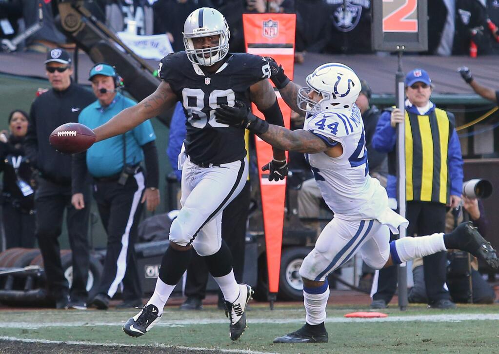 Oakland Raiders tight end Clive Walford scores a touchdown in front of Indianapolis Colts linebacker Antonio Morrison, during their game in Oakland on Saturday, Dec. 24. The Raiders defeated the Colts 33-25. (Christopher Chung / The Press Democrat)