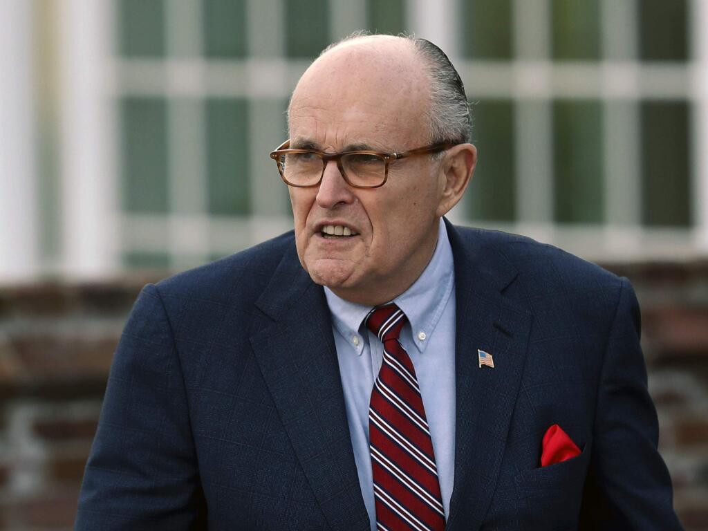 FILE - In this Nov. 20, 2016 file photo, former New York Mayor Rudy Giuliani arrives at the Trump National Golf Club Bedminster clubhouse in Bedminster, N.J. President Donald Trump's new lawyer Rudy Giuliani said Wednesday, May 2, 2018, the president repaid attorney Michael Cohen for a $130,000 payment to porn star Stormy Daniels. Giuliani made the revelation during an appearance on Fox News Channel's 'Hannity.' (AP Photo/Carolyn Kaster, File)