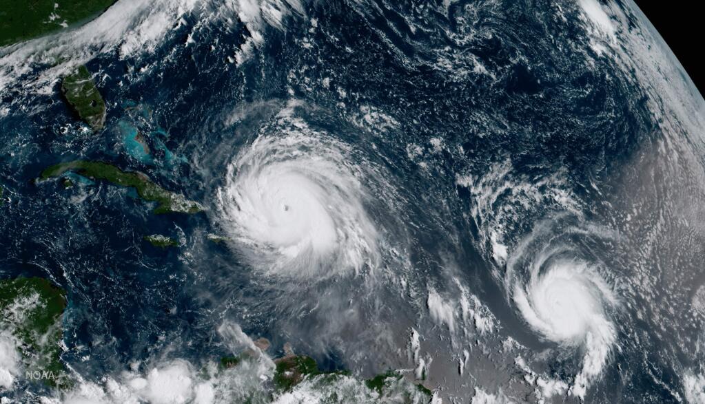 FILE - This Thursday, Sept. 7, 2017 GOES-16 satellite image shows the eye of Hurricane Irma, left, just north of the island of Hispaniola, with Hurricane Jose, right, in the Atlantic Ocean. In a four-week span, hurricanes Harvey, Irma and Maria ravaged Texas, Florida, Puerto Rico and other Caribbean islands. (NOAA via AP)