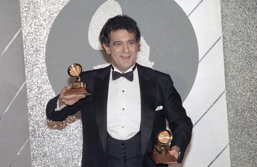 FILE - In this Feb. 26, 1985 file photo, Placido Domingo holds his two trophies during the Grammy Awards ceremonies. Eight opera singers and a dancer have told The Associated Press that they were sexually harassed by Domingo, one of the most celebrated and powerful men in their industry. The women say the encounters took place over three decades, at venues that included opera companies where he held top managerial positions. (AP Photo/File)