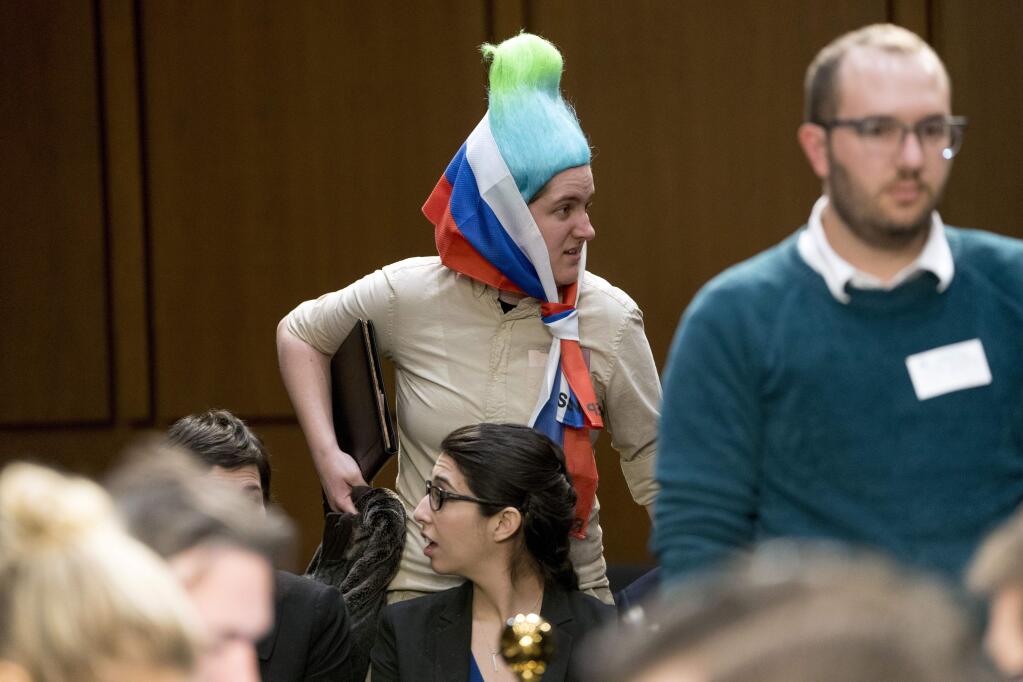 A woman wearing a blue and green pointy wig, aiming to look like a Russian troll, arrives before Facebook CEO Mark Zuckerberg arrives at a joint hearing of the Commerce and Judiciary Committees on Capitol Hill in Washington, Tuesday, April 10, 2018, about the use of Facebook data to target American voters in the 2016 election. (AP Photo/Andrew Harnik)