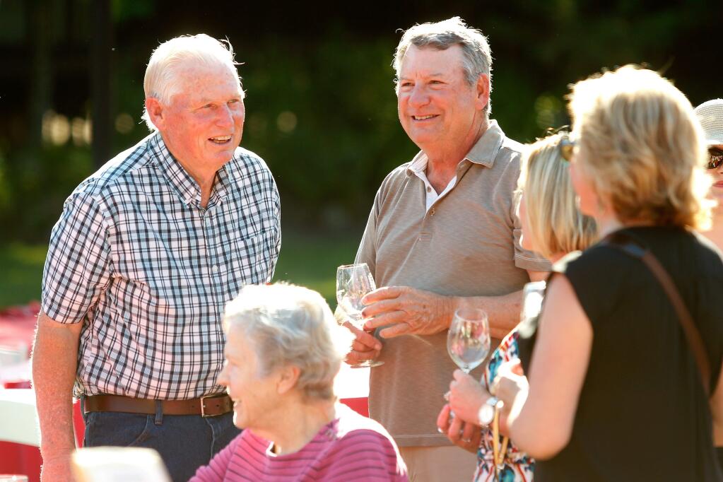 Richard Hughes, left, recipient of the Luther Burbank Conservation Award, talks with his hay vendor Jens Kullberg, center, and his wife Beckie Kullberg during Sonoma County Farm Bureau's Love of the Land event at Richard's Grove and Saralee's Vineyard in Windsor, California on Friday, July 15, 2016. (Alvin Jornada / The Press Democrat)