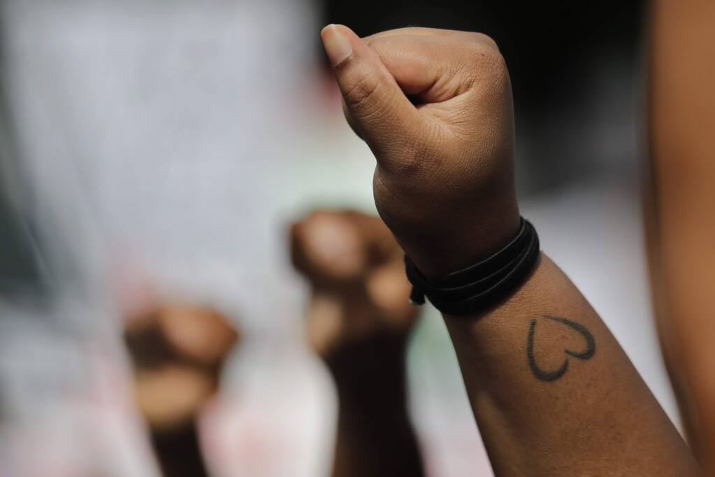 People hold up clenched fists during a protest against the mistreatment of Black people and to let lawmakers know they want policy change, at the Georgia State Capitol on Monday, June 15, 2020, in Atlanta. (Brynn Anderson/Associated Press)