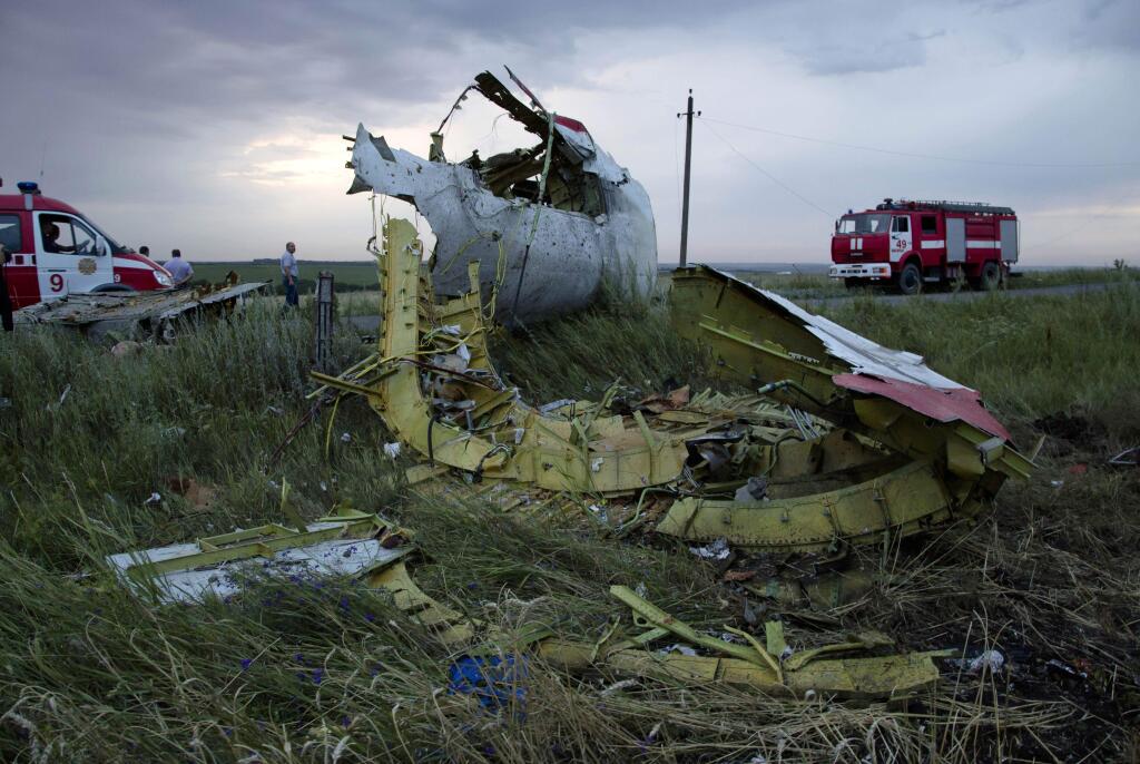 In this Thursday, July 17, 2014 file photo, firefighters arrive at the crash site of a passenger plane near the village of Hrabove, Ukraine. (AP Photo/Dmitry Lovetsky)