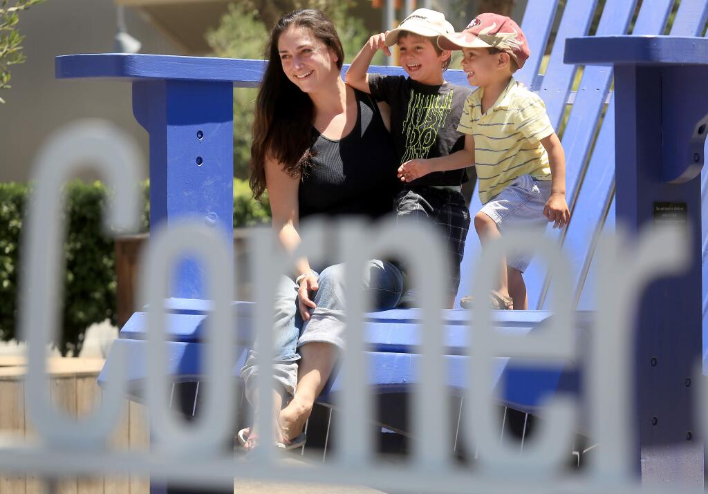Sonoma residents Jennea Priestley and her son Jonas along with his friend Jason Carey have their photograph taken in the iconic blue chair at Cornerstone Gardens in Sonoma on Tuesday, June 2, 2015. (KENT PORTER/ PD)