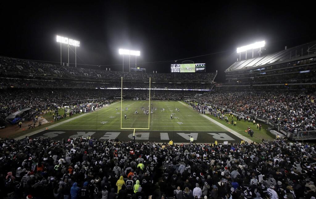 FILE - In this Monday, Dec. 24, 2018, file photo, fans watch from a general view at Oakland Alameda County Coliseum during the second half of an NFL football game between the Oakland Raiders and the Denver Broncos in Oakland, Calif. The Raiders still might play another season in Oakland after all. (AP Photo/Jeff Chiu, File)