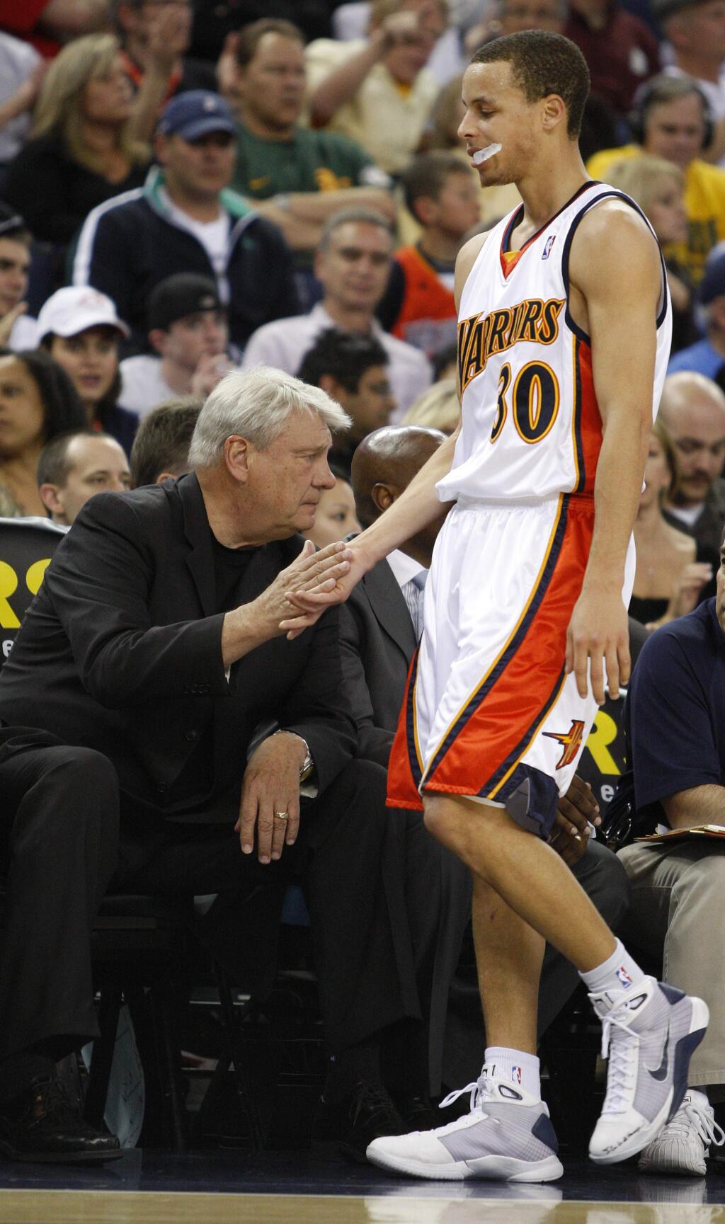 Then-Golden State Warriors coach Don Nelson, left, shakes the hand of Warriors guard Stephen Curry during the first half against the Utah Jazz on Tuesday, April 13, 2010, in Oakland. (AP Photo/Ben Margot)