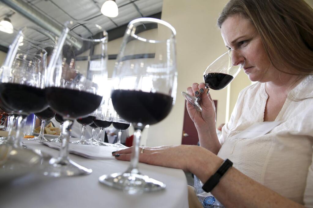 Judge Amanda Garland smells a glass of wine during the North Coast Wine Challenge held at Saralee and Richard's Barn at the Sonoma County Fairgrounds in the Santa Rosa, on Wednesday, April 11, 2018. (BETH SCHLANKER/ The Press Democrat)