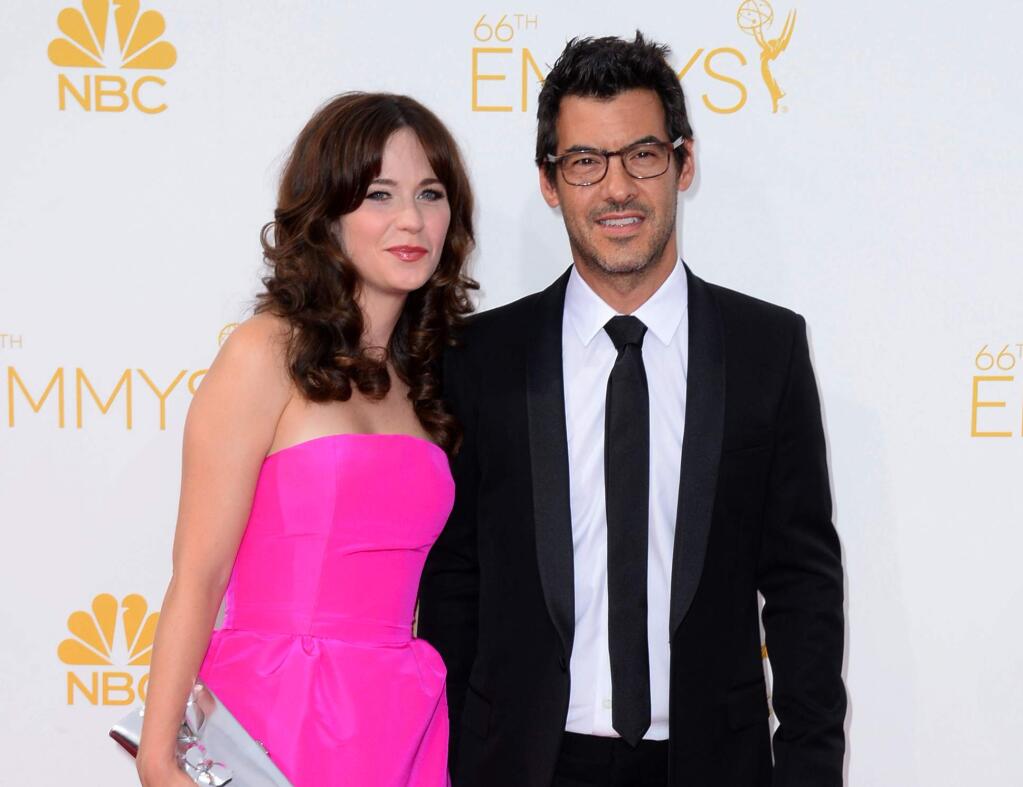 Zooey Deschanel, left and Jacob Pechenik arrive at the 66th Annual Primetime Emmy Awards at the Nokia Theatre L.A. Live on Monday, Aug. 25, 2014, in Los Angeles. Deschanel is expecting a baby with her producer boyfriend, Jacob Pechenik. The couple released a statement to People magazine Tuesday, Jan. 13, 2015, saying they are 'over the moon' and 'excited to meet our little one,' who is due in the summer. (Photo by Jordan Strauss/Invision/AP, File)