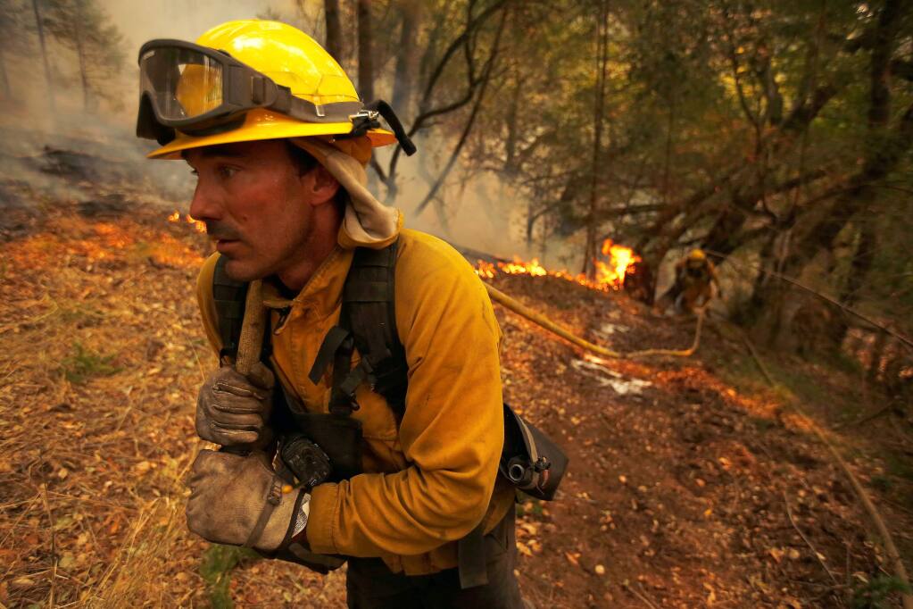 North Lake Tahoe firefighter Julien Lecorps advances a hose lay along a containment line near homes to protect them from the Nuns fire around Hood Mountain Regional Park in Santa Rosa, California on Monday, October 16, 2017. (Alvin Jornada / The Press Democrat)