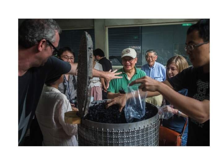 PHOTO: 1 no credit -Astrophysicist Frank Shu, center, and his team with a tub of biochar produced using his molten-salt process module.