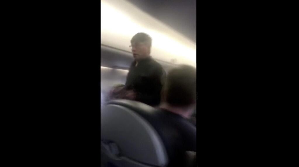 This Sunday, April 9, 2017, image made from a video provided by Audra D. Bridges shows a passenger who was removed from a United Airlines flight in Chicago. (Audra D. Bridges via AP)