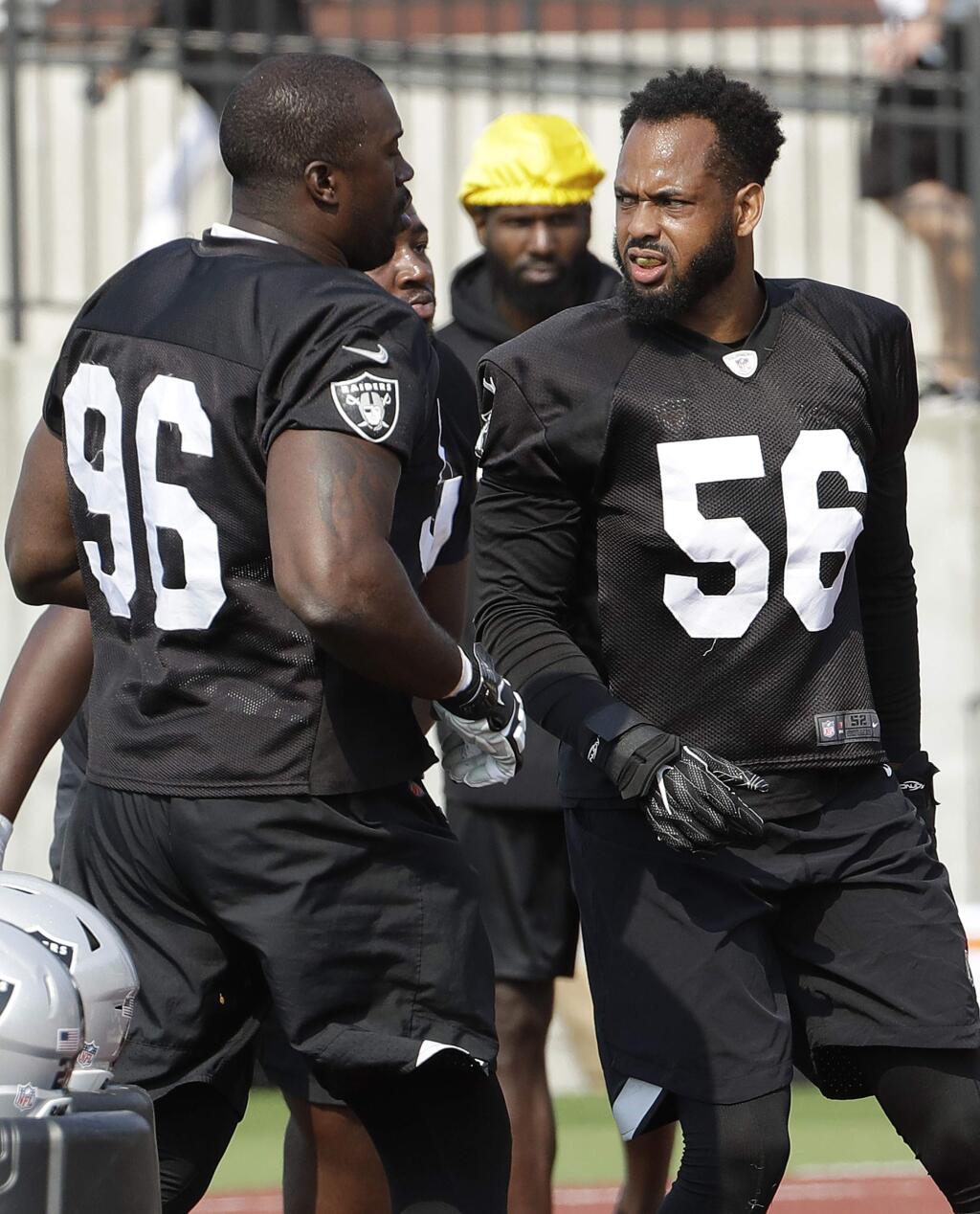 The Oakland Raiders' Tank Carradine, left, talks with Derrick Johnson, right,during practice in Napa earlier this month. (Associated Press / Jeff Chiu)