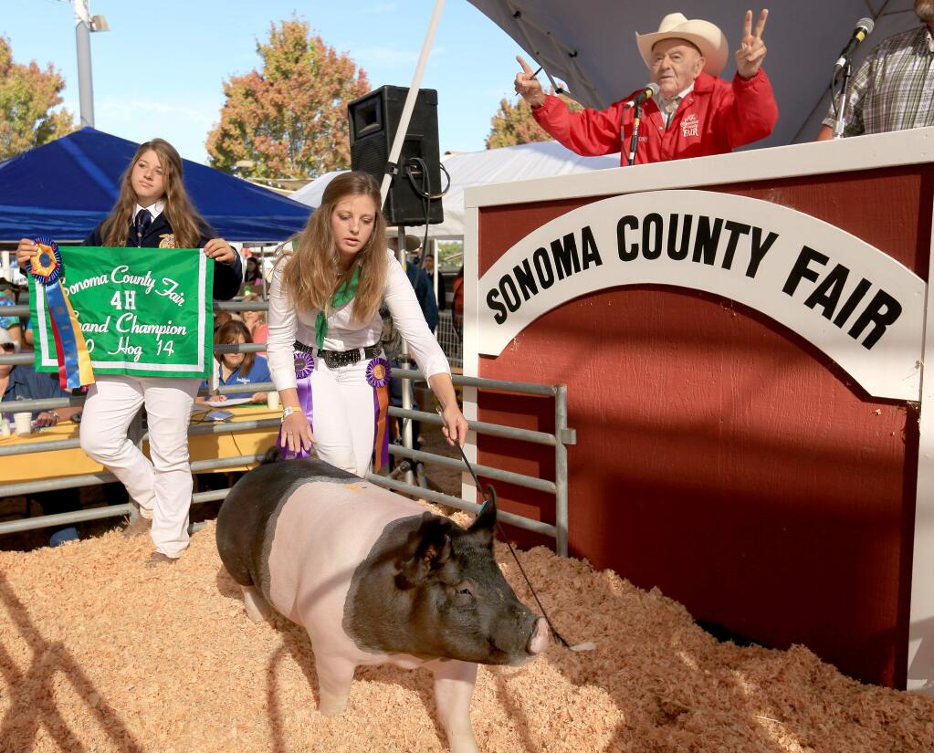 Gianna Ricci of Live Oak 4H shows her hog at the Sonoma County Fair hog auction in Santa Rosa. At left is Courtney King, Friday Aug. 1, 2014. Ricci's hog was the grand champion. (Kent Porter / Press Democrat)