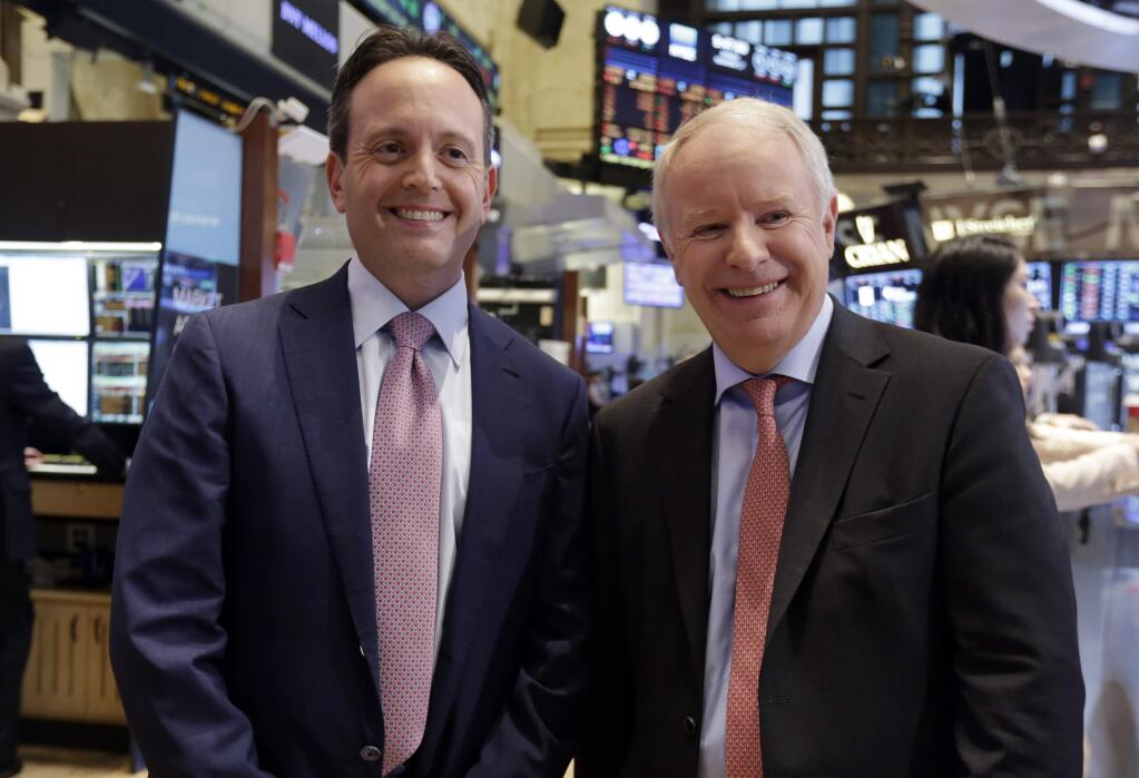 Actavis CEO Brenton Saunders, left, and Allergan CEO David Pyott posse for a photo on the floor of the New York Stock Exchange Monday, Nov. 17, 2014. Allergan has reached a friendly deal to be acquired by Actavis PLC in a deal valued at US$66 billion blocking an attempted hostile takeover by a Canadian company and its U.S. backer. (AP Photo/Richard Drew)