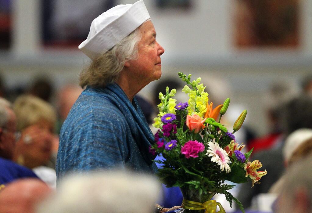 Kathy Morgan delivers a bouquet of flowers during the Tribute to Veterans lunch sponsored by the Kiwanis and Rotary Clubs at the Santa Rosa Veteran's building on Thursday, November 6, 2104.