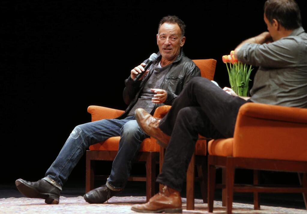 In this photo taken Wednesday, Oct. 6, 2016, musician Bruce Springsteen talks about his book 'Born to Run' with Dan Stone, right, during an event at the Nourse Theater in San Francisco. Springsteen credits his music with helping him navigate depression, and says playing marathon shows until he was exhausted helped chase away the blues.Springsteen spoke to an adoring, sold-out crowd on Wednesday night, in a 1-hour, 20-minute on-stage interview as part of a nationwide tour for his best-selling new autobiography. (Scott Strazzante/San Francisco Chronicle via AP)