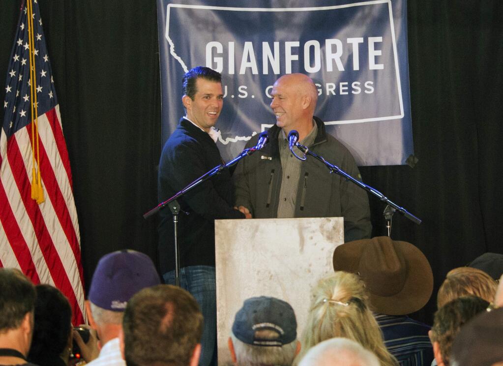 FILE - In this May 11, 2017, file photo Republican Greg Gianforte, right, welcomes Donald Trump Jr., the U.S. president's son, onto the stage at a rally in East Helena, Mont. Gianforte won Montana's only U.S. House seat on Thursday, May 25, despite being charged a day earlier with assault after witnesses said he grabbed a reporter by the neck and threw him to the ground. (AP Photo/Bobby Caina Calvan, File)