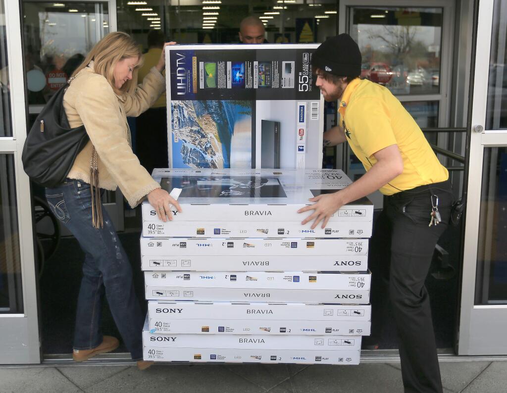 Best Buy employee Steven Cannady assists Debra Ripka of Forestville with her newly purchased televisions, Friday Nov. 28, 2014 in Santa Rosa. (Kent Porter / Press Democrat) 2014