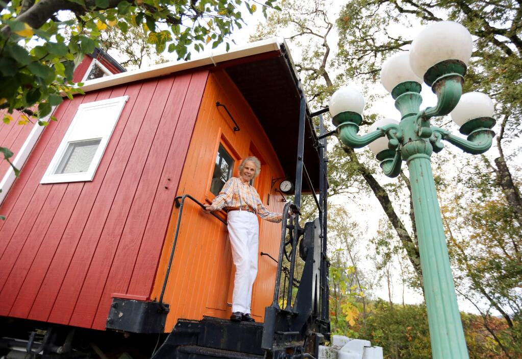 Sylvia Linde stands on the caboose that sits on her Cloverdale property, Thursday, November 13, 2014. (Crista Jeremiason / The Press Democrat)