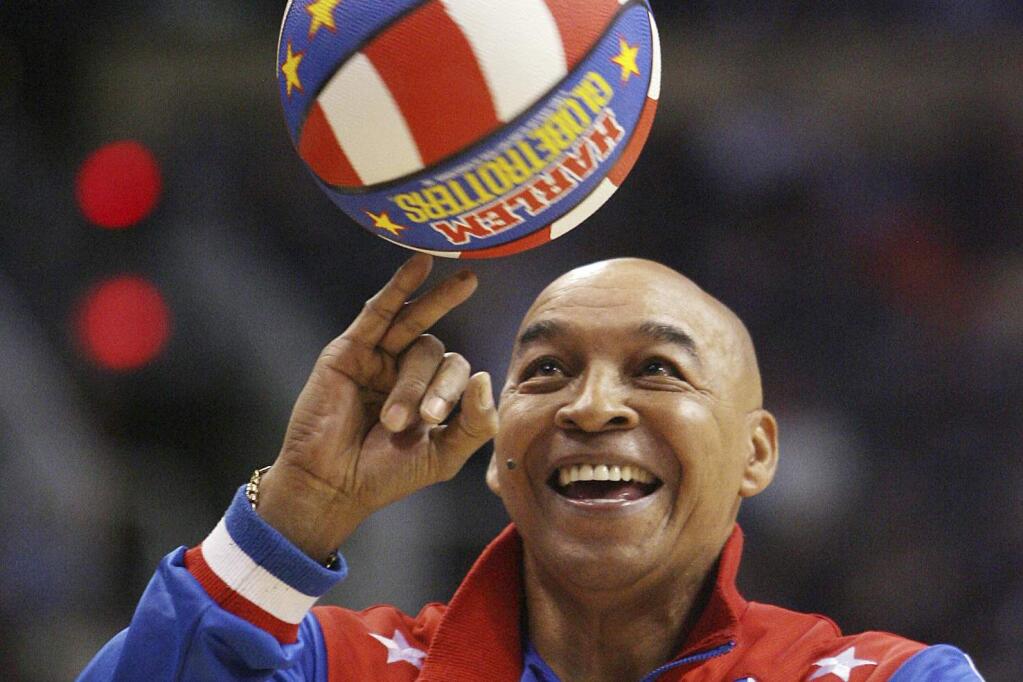 FILE - In this Jan. 9, 2008, file photo, the Harlem Globetrotters' Fred 'Curly' Neal performs during a timeout in the second quarter in an NBA basketball game between the Indiana Pacers and the Phoenix Suns in Phoenix. Neal, the dribbling wizard who entertained millions with the Harlem Globetrotters for parts of three decades, has died the Globetrotters announced Thursday, March 26, 2020. He was 77. Neal played for the Globetrotters from 1963-85, appearing in more than 6,000 games in 97 countries for the exhibition team known for its combination of comedy and athleticism. (AP Photo/Ross D. Franklin, File)