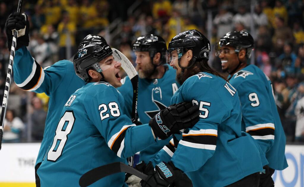 The San Jose Sharks' Timo Meier (28) celebrates with Erik Karlsson (65) and Evander Kane (9) after scoring against the Vancouver Canucks during the first period Saturday, Feb. 16, 2019, in San Jose. (AP Photo/Josie Lepe)