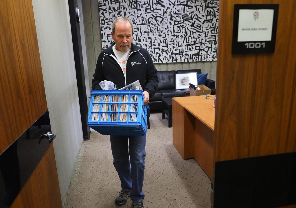 Outgoing Santa Rosa Mayor Chris Coursey carries a box of belongings out of his City Hall office in Santa Rosa on Monday, December 17, 2018. (Christopher Chung/ The Press Democrat)