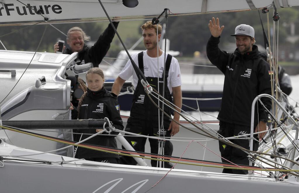 Climate change activist Greta Thunberg and the crew wave from Malizia II boat as they depart in Plymouth, England, Wednesday, Aug. 14, 2019. The 16-year-old climate change activist who has inspired student protests around the world will leave Plymouth, England, bound for New York in a high-tech but low-comfort sailboat.(AP Photo/Kirsty Wigglesworth, pool)
