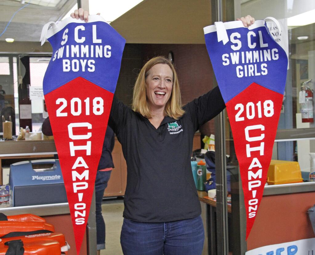 Bill Hoban/Index-Tribune An ecstatic Coach Jane Hansen waves the Sonoma County League pennants the Sonoma Valley High Dragon swim teams won Saturday. It was the second straight year the Dragons have swept the meet - and the fourth straight championship for the boys.