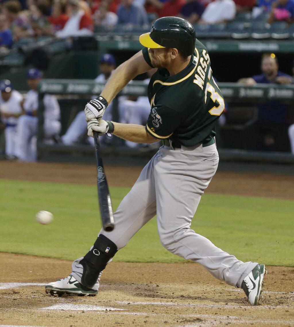 Oakland Athletics' Brandon Moss swings for a strike during the first inning of a baseball game against the Texas Rangers in Arlington, Texas, Thursday, Sept. 25, 2014. (AP Photo/LM Otero)