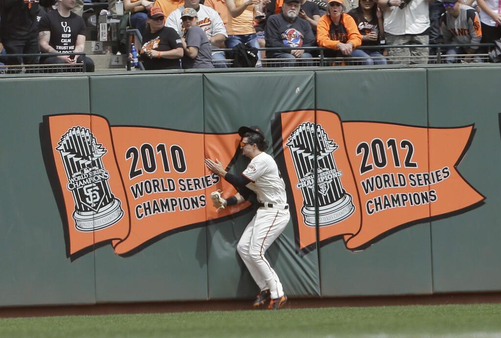 San Francisco Giants left fielder Jarrett Parker hits the outfield wall after catching a fly ball hit by the Colorado Rockies' DJ LeMahieu during the fourth inning in San Francisco, Saturday, April 15, 2017. Parker was injured on the play and left the game. (AP Photo/Jeff Chiu)