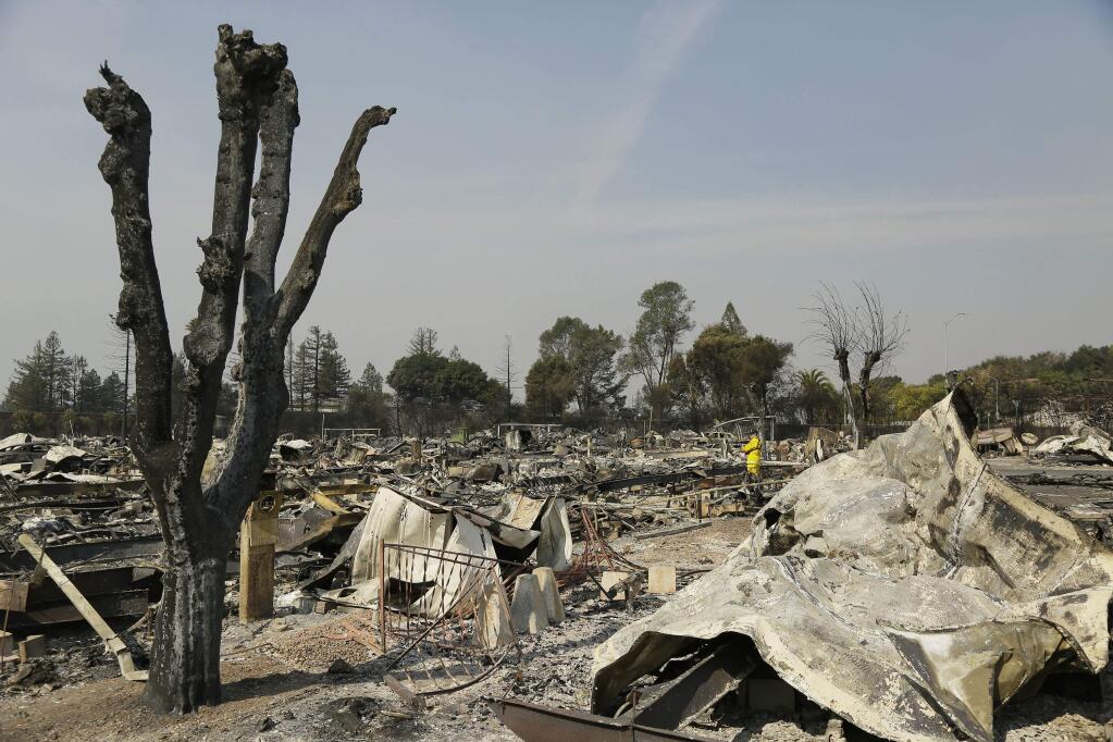A Cal Fire official looks out at the remains of the Journey's End mobile home park Wednesday, Oct. 11, 2017, in Santa Rosa, Calif. Blazes burning in Northern California have become some of the deadliest in state history. (AP Photo/Eric Risberg)