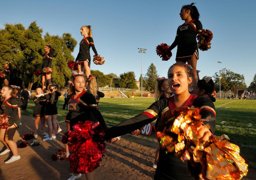 Cardinal Newman sophomore Eternity McDonnell, at right, and the rest of the Cardinal Newman cheerleaders get fans pumped up at the start of a varsity football game between Fortuna and Cardinal Newman high schools at Healdsburg Recreation Park, in Healdsburg, California, on Thursday, August 22, 2019. (Alvin Jornada / The Press Democrat)