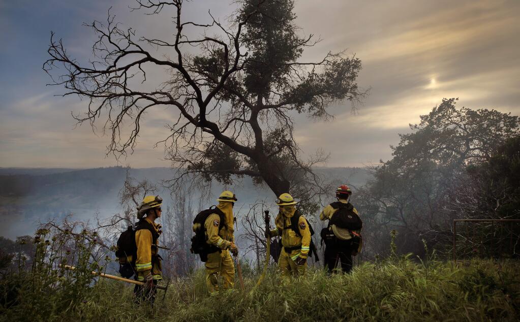 Firefighters with Cal Fire and Sonoma County Fire District prepare to extinguish a flames on a brush fire in Rincon Valley on Rolling Oaks Road, Thursday, April 30, 2020. (Kent Porter / The Press Democrat) 2020