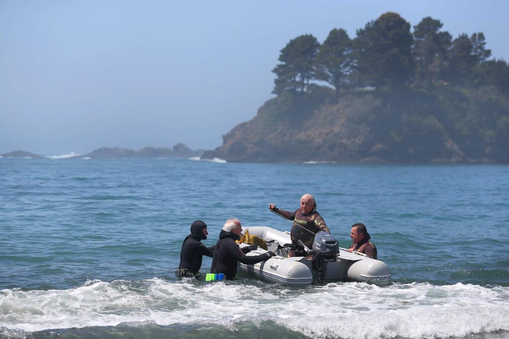 Ken Hardy, left, Jerry Casey, Ed Balbas, and Brian Balbas launch their boat to go abalone diving at Van Damme State Park, near Little River, Calif. (Christopher Chung/ The Press Democrat)
