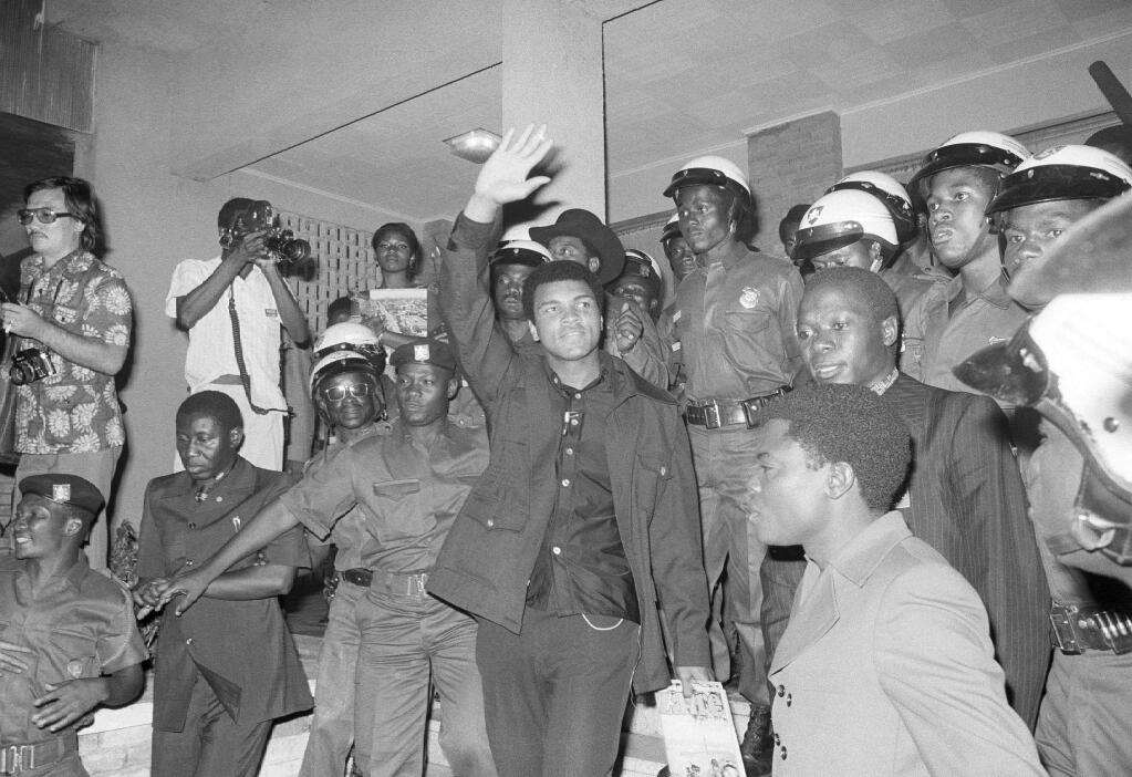 FILE - In this Sept. 11, 1974, file photo, heavyweight title challenger Muhammad Ali, surrounded by Zaire soldiers, waves to crowd upon his arrival in Kinshasha, Zaire. Ali is in Zaire for a fight against George Foreman. Ali, the magnificent heavyweight champion whose fast fists and irrepressible personality transcended sports and captivated the world, has died according to a statement released by his family Friday, June 3, 2016. He was 74. (AP Photo/Horst Faas, File)